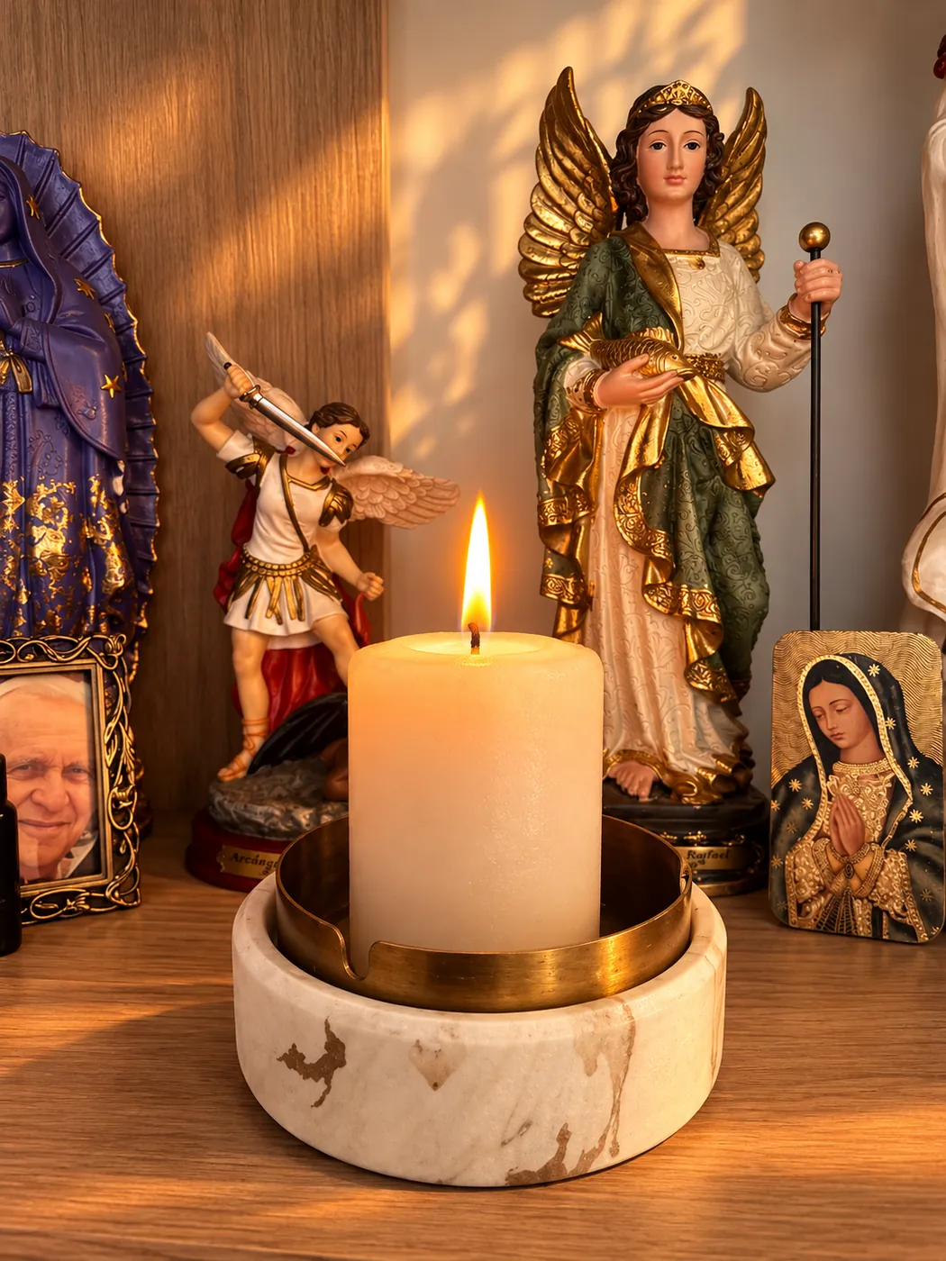 Vela Madre encendida en un altar junto a imágenes religiosas